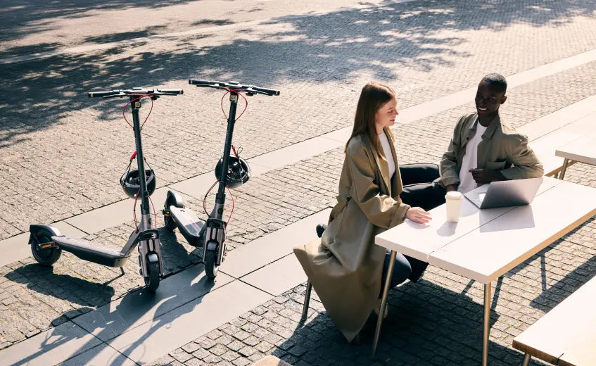 Trottinette électrique Segway Ninebot F3 E stationnée en ville près d'une terrasse