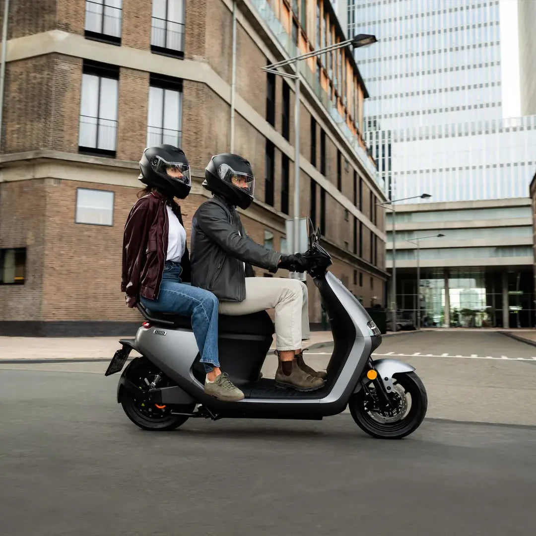 Deux personnes circulant en ville sur le scooter électrique Segway E250 S