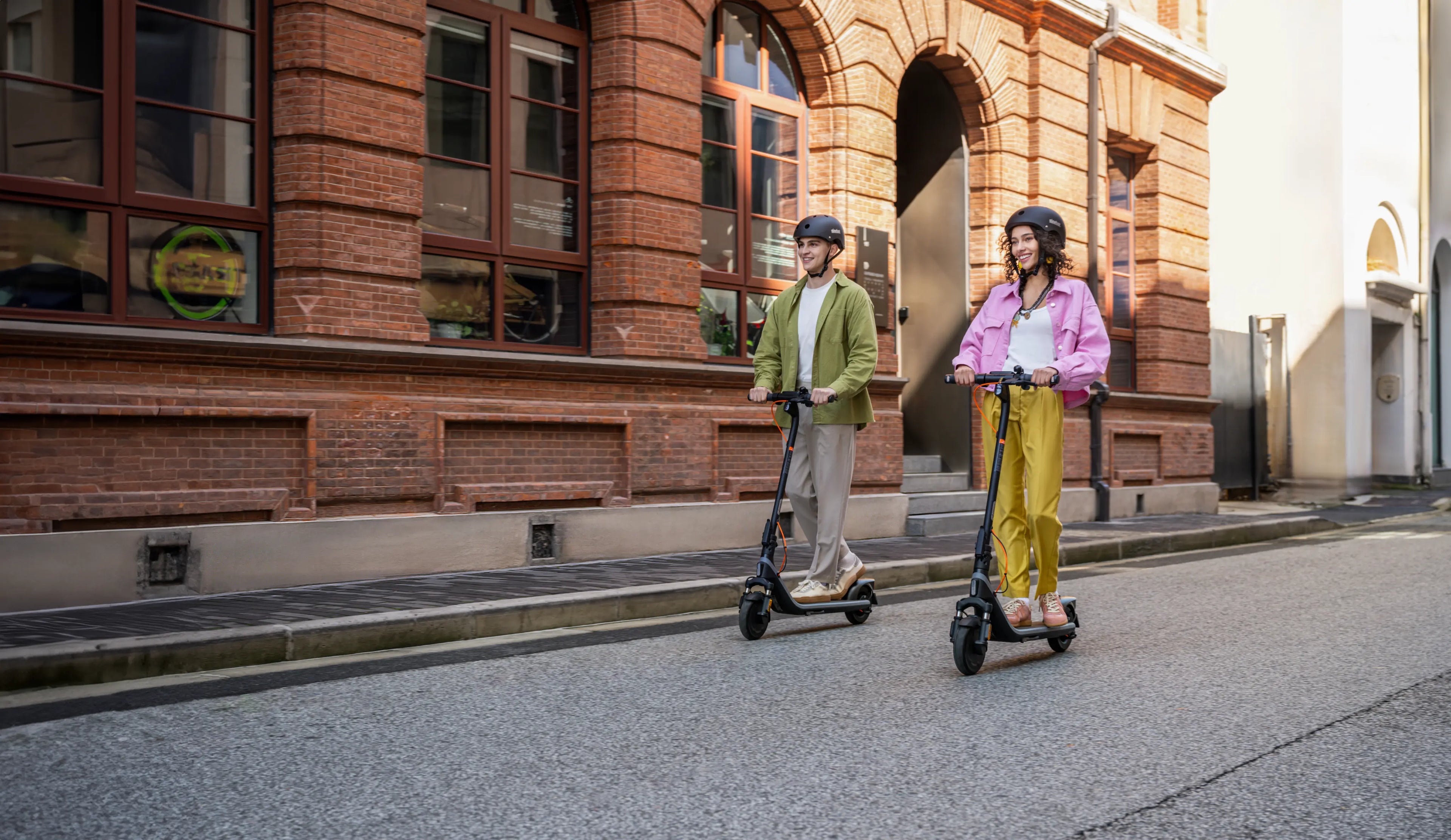 Deux personnes roulant sur des trottinettes Segway Ninebot E2 Plus E II en rue