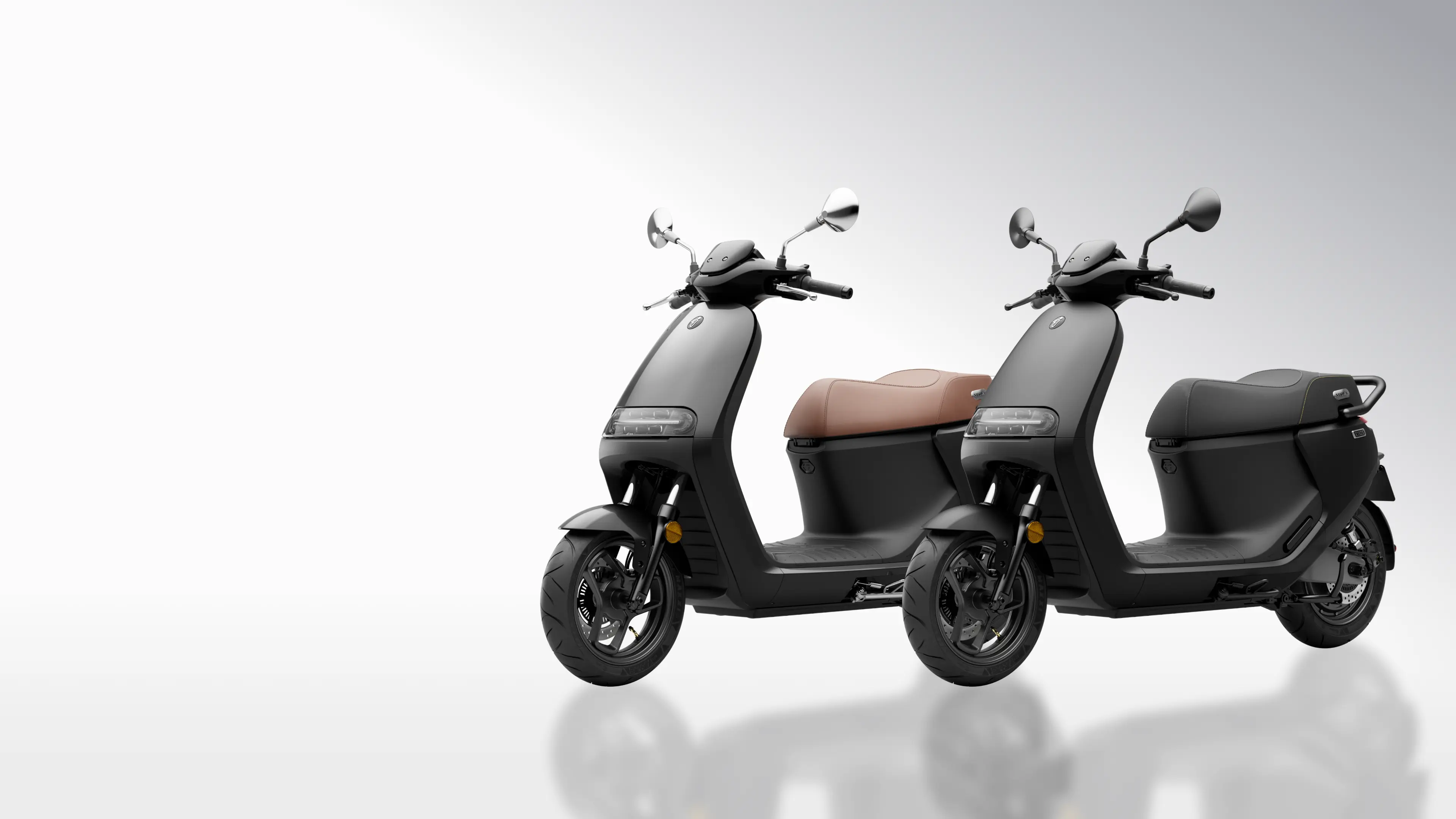 Deux scooters électriques Segway E150 S en studio, selles noire et marron