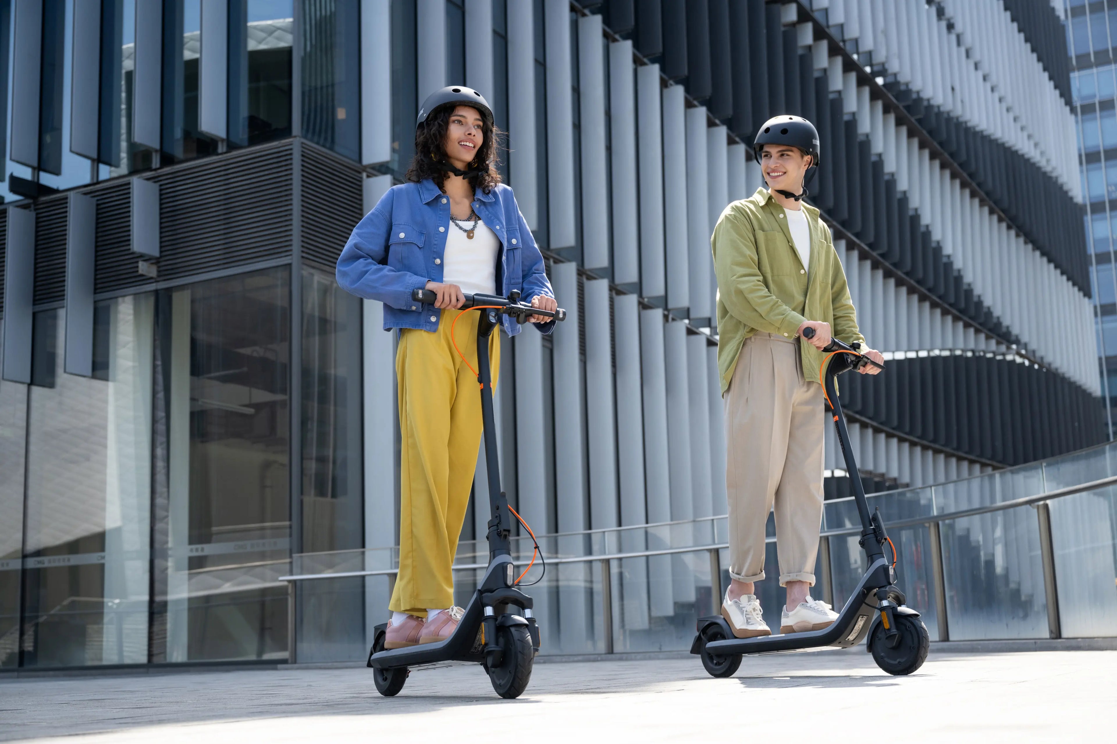 Homme et femme avec leurs trottinettes électriques Segway Ninebot E2 Plus E II en ville