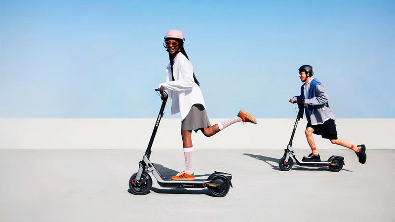 Deux personnes roulant sur des trottinettes électriques Segway Ninebot E3 E