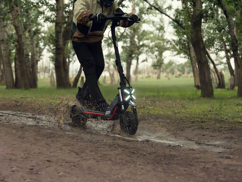 Trottinette tout-terrain Segway ZT3 Pro E franchissant une flaque de boue