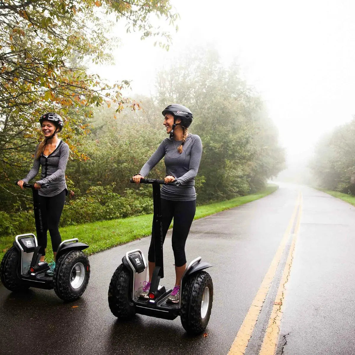 Deux personnes en balade sur des gyropodes Segway X2 SE sur route brumeuse