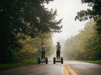 Deux personnes sur des gyropodes Segway X2 SE sur une route forestière brumeuse