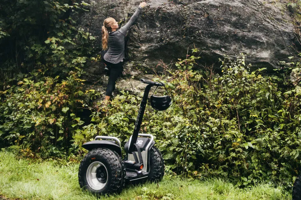 Femme cueillant des mûres depuis un gyropode Segway X2 SE